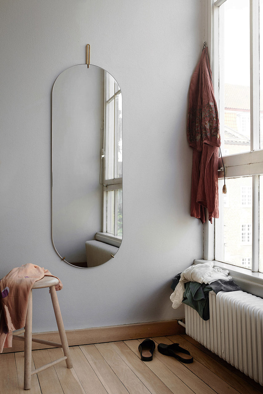 Moebe tall wall mirror aan muur naast raam en stoel